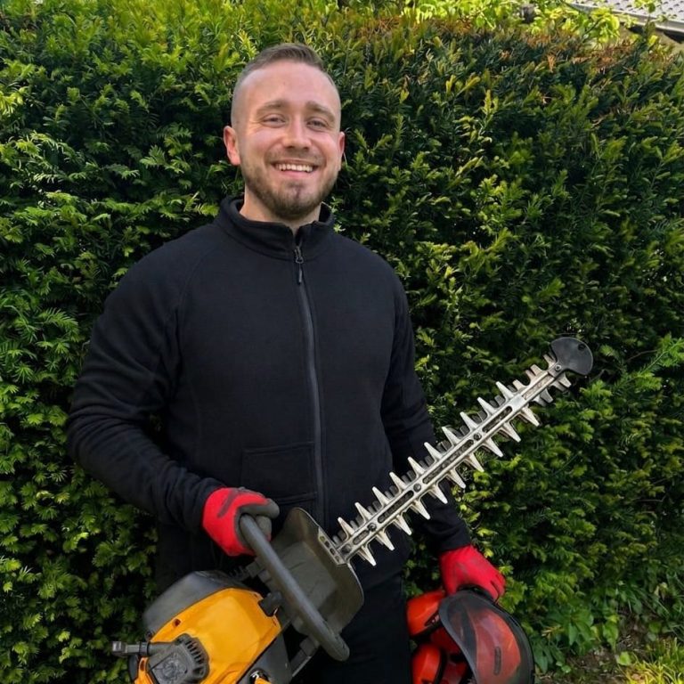 Inhaber Nico Heidrich von Gartenservice Heidrich aus Würzburg mit einer Heckenschere bei der Arbeit